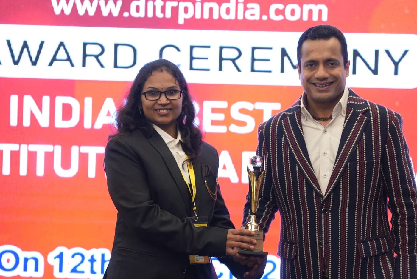 A winning institute head receiving a trophy at the 2023 award show